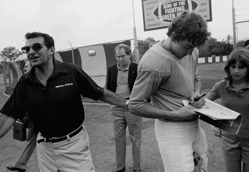 Joe Paterno tries to pull Todd Blackledge away from signing autographs in 1982. Jack Thornell/AP Images